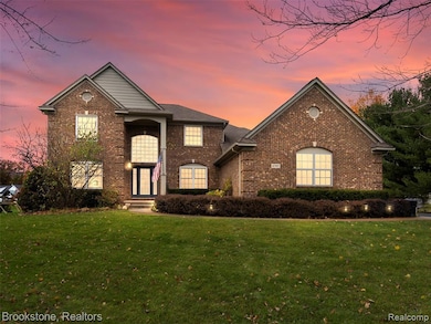 View of front of house with a lawn and brick siding