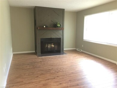The  Living room with a fireplace  and laminate flooring is to the right as you enter the home