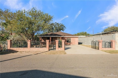 View of front of house with a fenced front yard, a gate, and brick siding