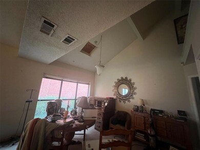 Living room featuring vaulted ceiling and a textur