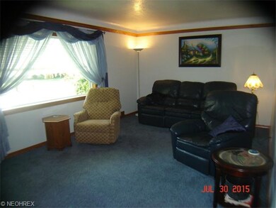 Living room has a large picture window, hardwood u