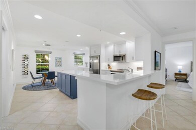 Kitchen featuring a kitchen bar, recessed lighting, ornamental molding, white cabinets, and hanging light fixtures