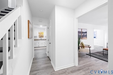 Hallway with light wood-style flooring and baseboards