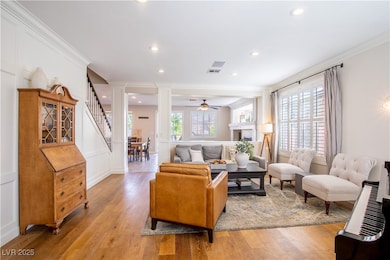 Living area with stairs, crown molding, light wood