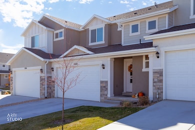 View of front of home featuring stone siding, a shingled roof, concrete driveway, and board and batten siding