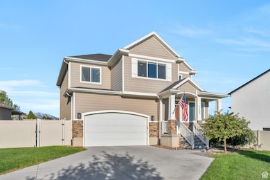 View of front of home featuring a gate, an attached garage, driveway, and stone siding