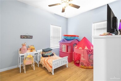 Bedroom with wood finished floors, a ceiling fan, and baseboards