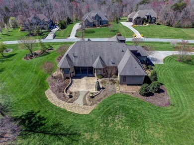 Aerial view showing the rear architecture of the home and the extensive planting beds and hardscape.  The clubhouse and pool and trail entrance are all a short walk away.