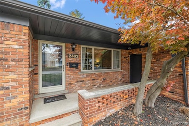 View of exterior entry featuring brick siding and covered porch