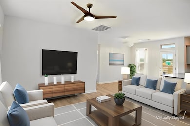 Living area with wood finished floors, ceiling fa