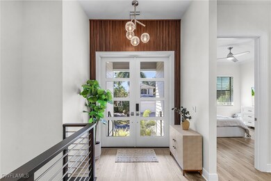 Entryway featuring wood finished floors, ceiling fan, and a chandelier