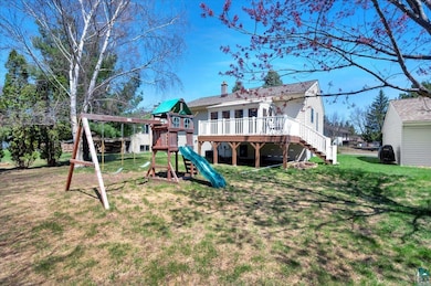 Rear view of house featuring a chimney, a lawn, a 