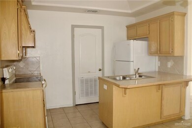 Kitchen featuring freestanding refrigerator, a peninsula, range with electric stovetop, a breakfast bar, and tasteful backsplash