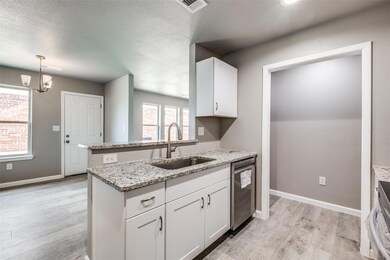 Kitchen featuring white cabinets, light stone coun
