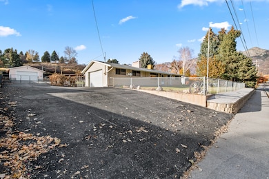 Ranch-style home featuring a fenced front yard, a detached garage, and a chimney