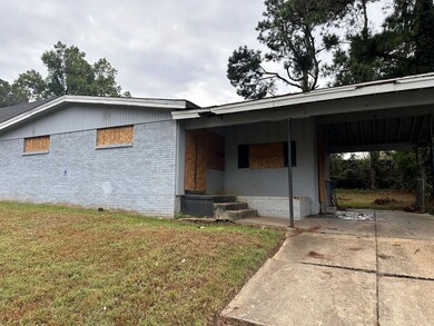 Exterior space with a lawn and a carport