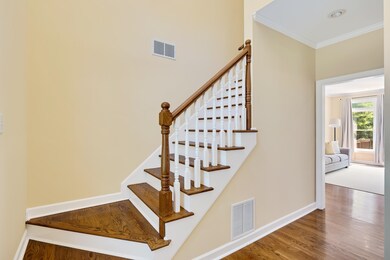 Staircase featuring crown molding and wood finished floors