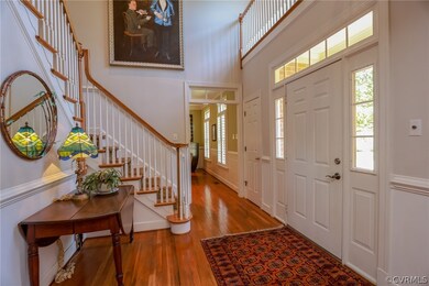 Foyer.  Note the transom windows, hardwoods, chair