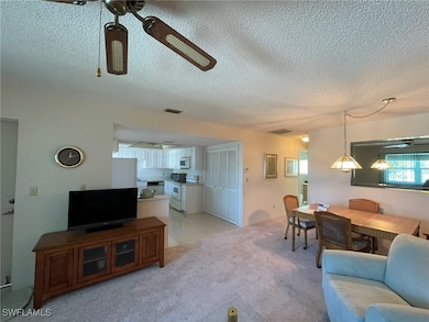 Living room featuring ceiling fan, light colored c