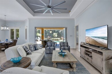 Living room with ceiling fan with notable chandeli