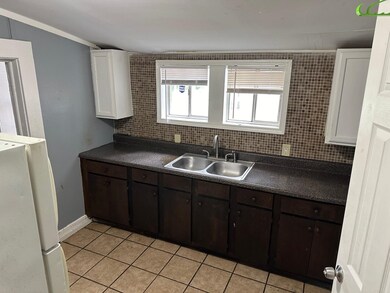 Kitchen with light tile patterned flooring, dark b