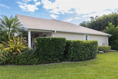 View of side of property with a yard, a shingled roof, and stucco siding