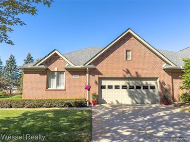 View of front of property with roof with shingles, a front lawn, brick siding, and concrete driveway