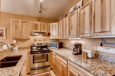 Kitchen featuring light stone counters, stainless