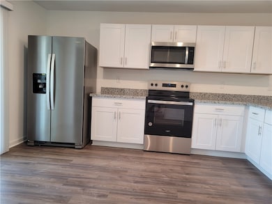 Kitchen with stainless steel appliances, white cab