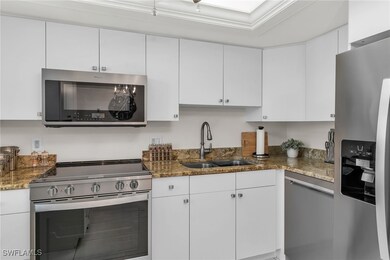 Kitchen with white cabinetry, a sink, stainless st