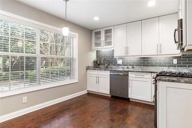 Kitchen with dark stone countertops, backsplash, d