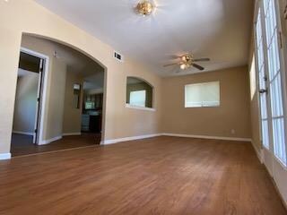 Spare room featuring arched walkways, baseboards,