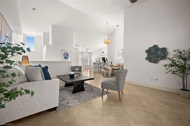 Living area with baseboards and high vaulted ceili