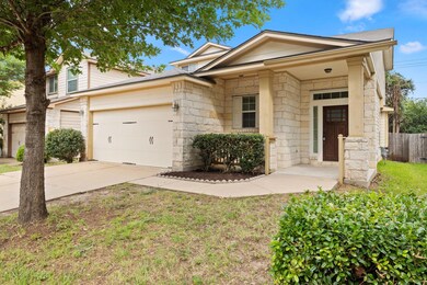 View of front of home with driveway, stone siding
