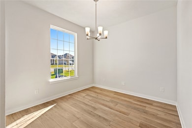 Spare room featuring light wood-style flooring and a chandelier