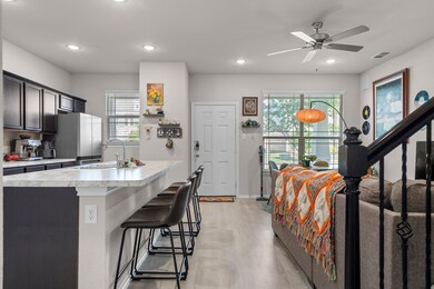 Kitchen with a sink, light countertops, freestanding refrigerator, and recessed lighting