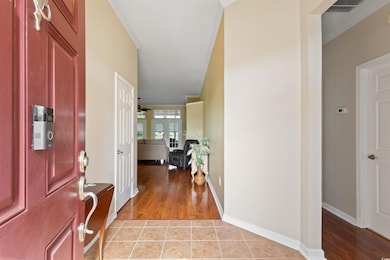 Entrance foyer with light wood-style flooring and ornamental molding