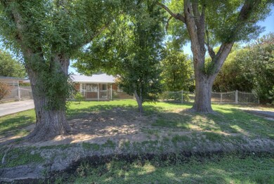 Front of home with tall mature trees.