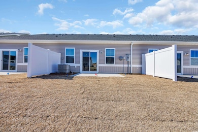 Rear view of house with central AC, a lawn, and fe