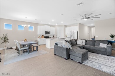 Living area with recessed lighting, wood finish floors, a ceiling fan, and a chandelier