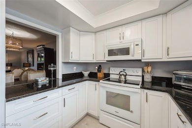 Kitchen with white appliances, white cabinetry, cr