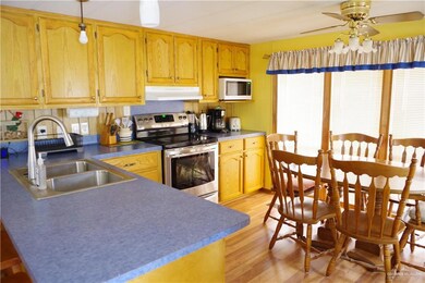 Kitchen featuring sink, ceiling fan, stainless steel range with electric cooktop, and light hardwood / wood-style floors