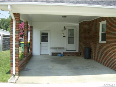 Carport showing entries into attached storage room and into Interior Utility Room