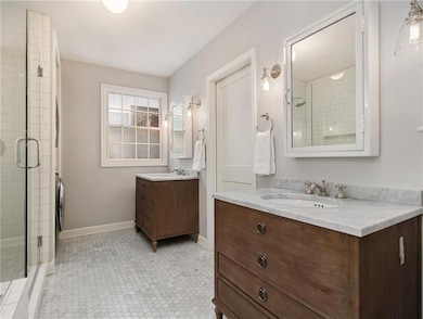 Bathroom featuring a shower with shower door, vani