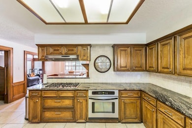 KITCHEN - with TONS of both cabinet and counter space, granite counter tops and stainless steel oven and 5 burner gas cooktop.