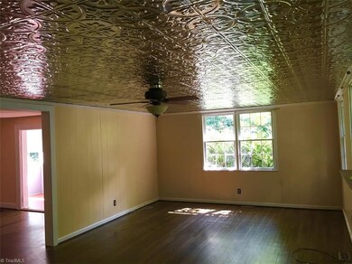 Den (Empty) with vintage style ceiling and original hardwood floors