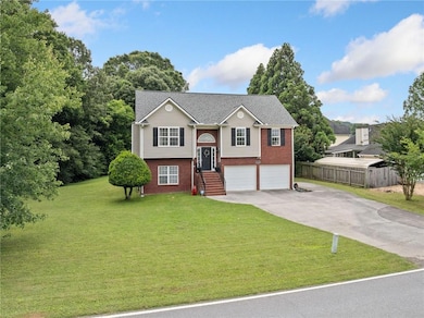 Split foyer home featuring brick siding, concrete driveway, and an attached garage