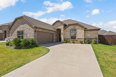 French country home featuring a garage, stone siding, roof with shingles, driveway, and brick siding