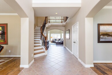 Another view into the light-filled entry hall looking toward the great family room and wrought iron stairway.