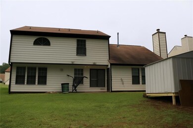 Back of property with a lawn